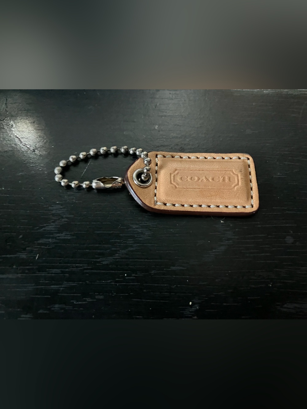 Coach hangtag charm is crafted from with a metallic chain